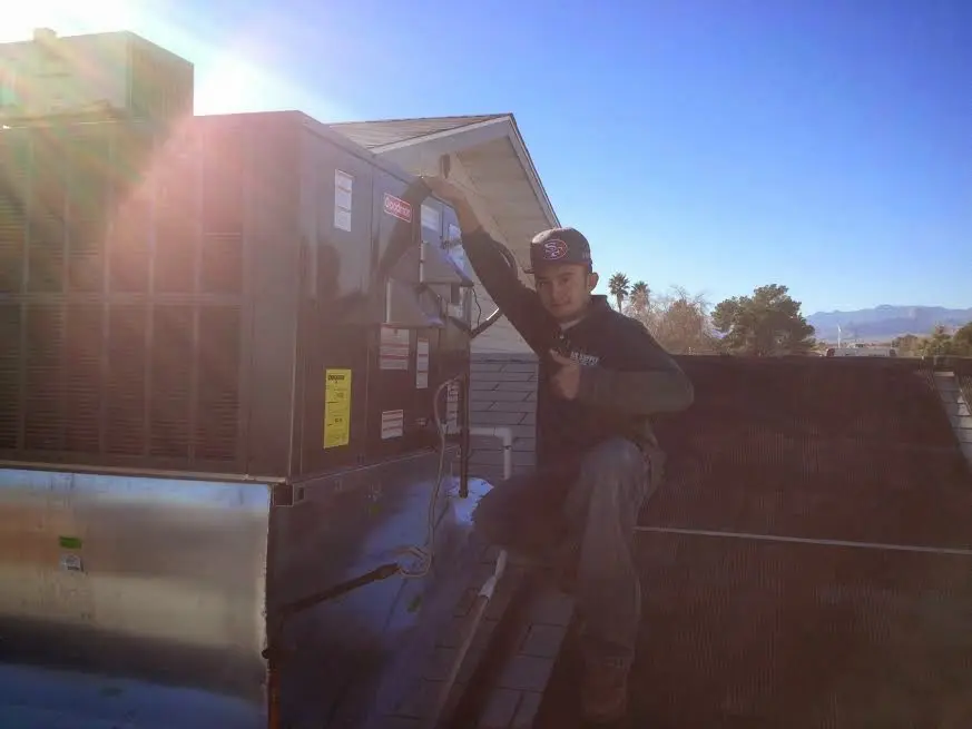 HVAC technician performing HVAC Inspection on a rooftop unit in Benner